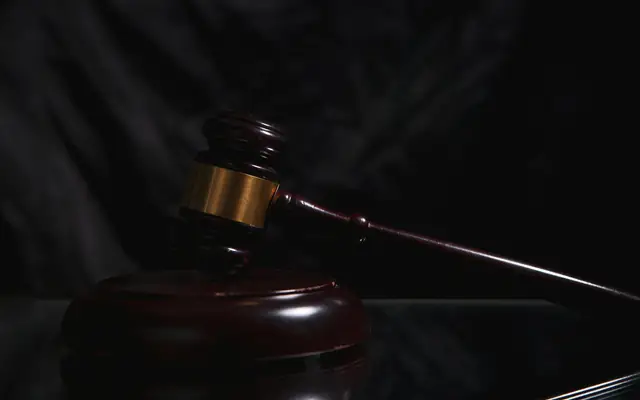 Mazo de juez en penumbra: defensa y querella por abuso sexual