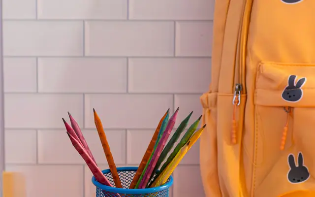 Mochila escolar y lápices sobre un escritorio